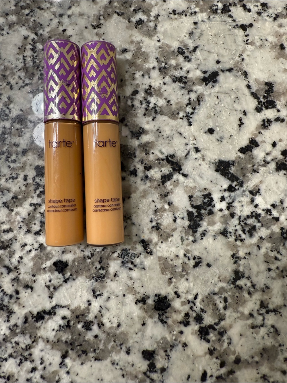 tarte concealer sticks with purple-and-gold patterned bases